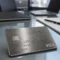 A premium metal credit card resting on a clean glass desk in a modern financial office.